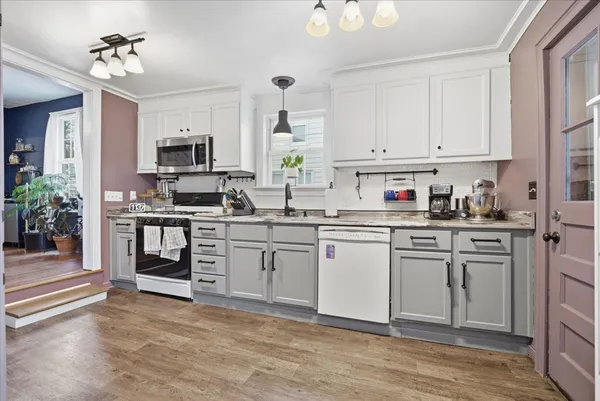 a kitchen with white cabinets and appliances
