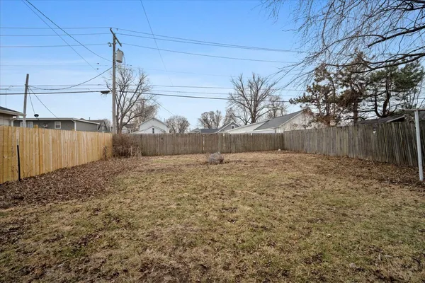 a front view of a house with a yard and a large tree