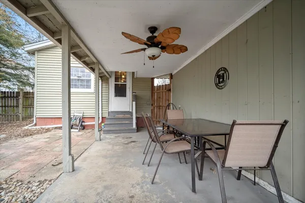 a view of a chair and table in backyard of house