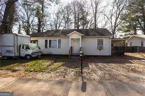 a front view of a house with a yard covered with snow in the background