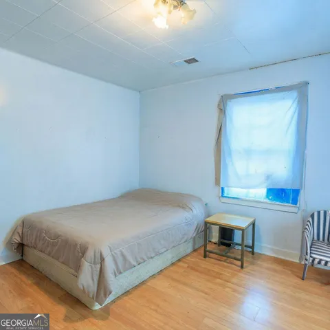 a bedroom with a bed a table and windows