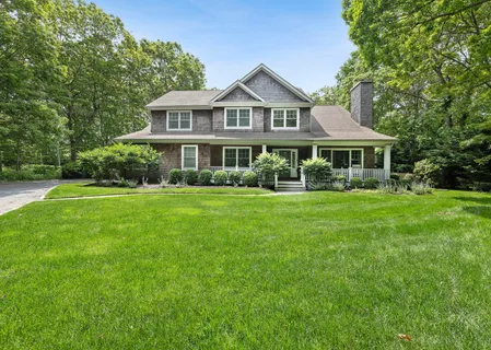 a front view of a house with a yard table and trees