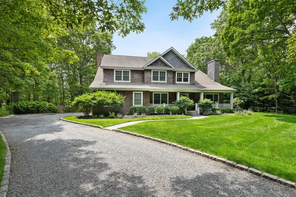 a front view of a house with a yard and trees