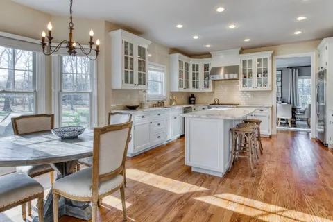 a large kitchen with cabinets table and chairs