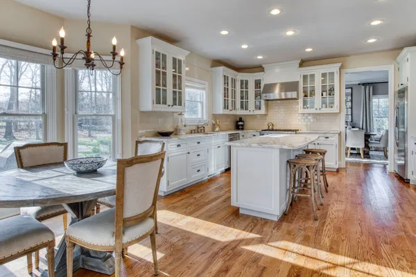 a large kitchen with cabinets table and chairs