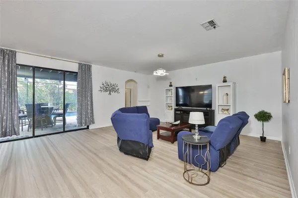 a living room with furniture a flat screen tv and a floor to ceiling window