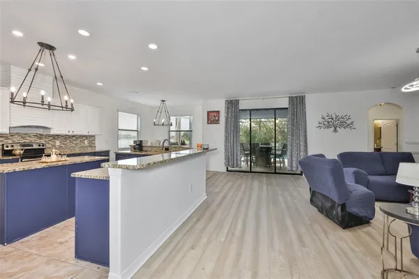 a living room with stainless steel appliances granite countertop furniture and a kitchen view