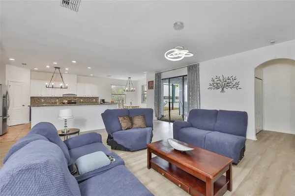 a living room with furniture and a view of kitchen