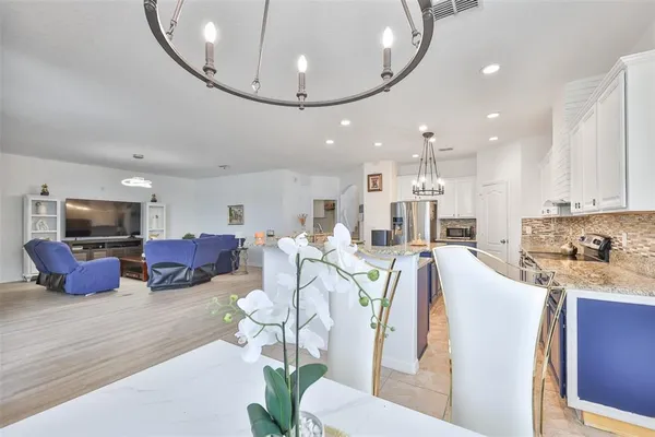 a living room with kitchen island furniture and a chandelier