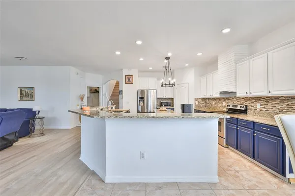 a kitchen with stainless steel appliances granite countertop a sink a stove top oven a counter space and cabinets