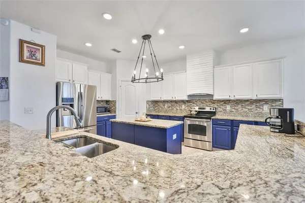 a kitchen with stainless steel appliances granite countertop a sink stove and refrigerator