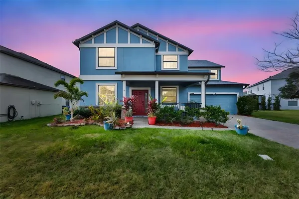 a view of a house with a yard and sitting area