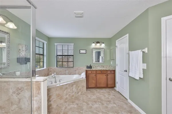 a spacious bathroom with a granite countertop tub sink and shower