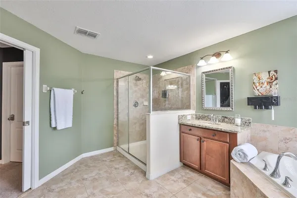 a bathroom with a granite countertop sink a mirror and a shower