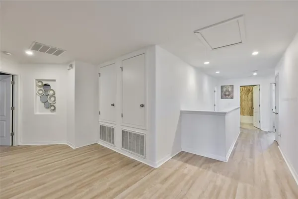 a view of an empty room with wooden floor and windows