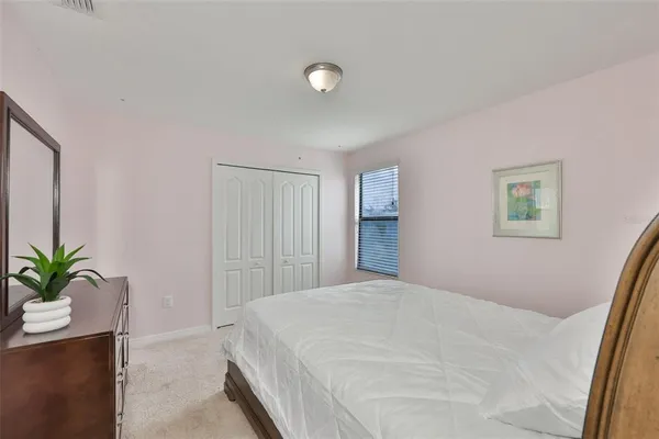 a bedroom with a bed and a potted plant