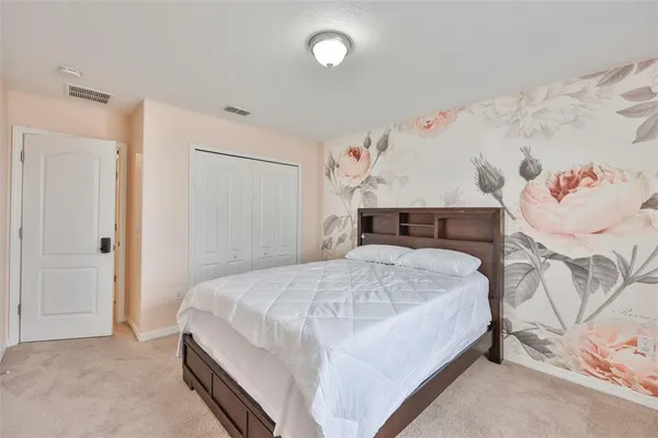 a bedroom with a bed and a wall painting