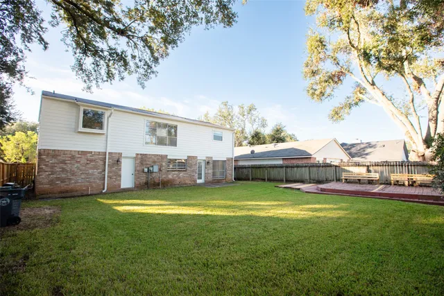 a view of a house with a big yard and large trees