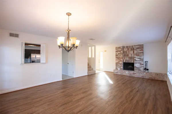 a view of a livingroom with wooden floor a fireplace and windows