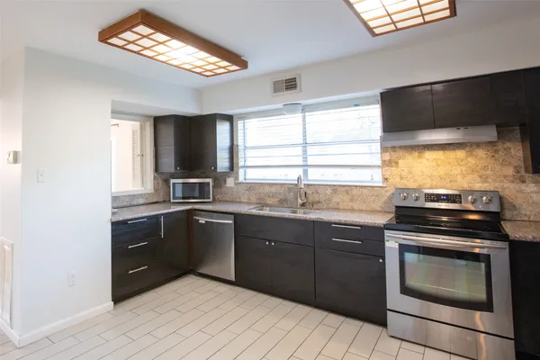 a kitchen with a sink stove and microwave