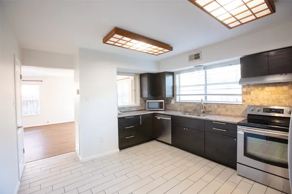 a kitchen with stainless steel appliances granite countertop a sink and stove top oven