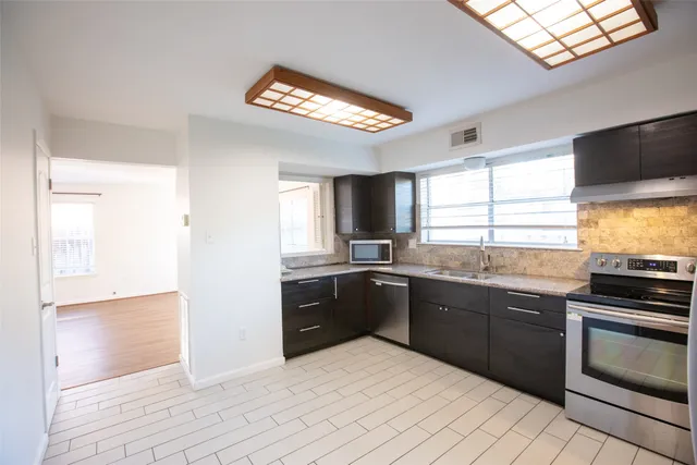 a kitchen with stainless steel appliances granite countertop a sink and stove top oven
