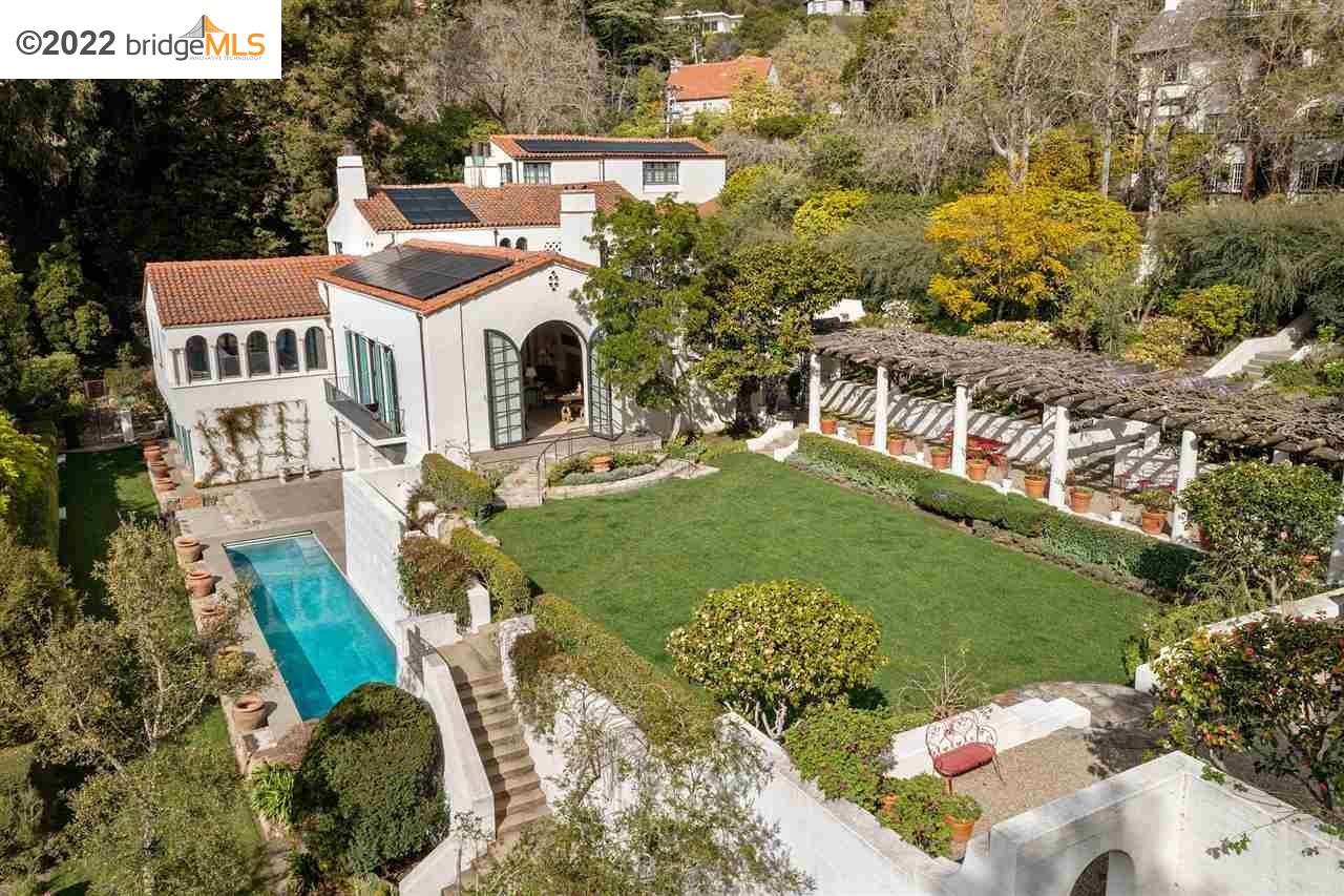 a view of a white house with a big yard and potted plants