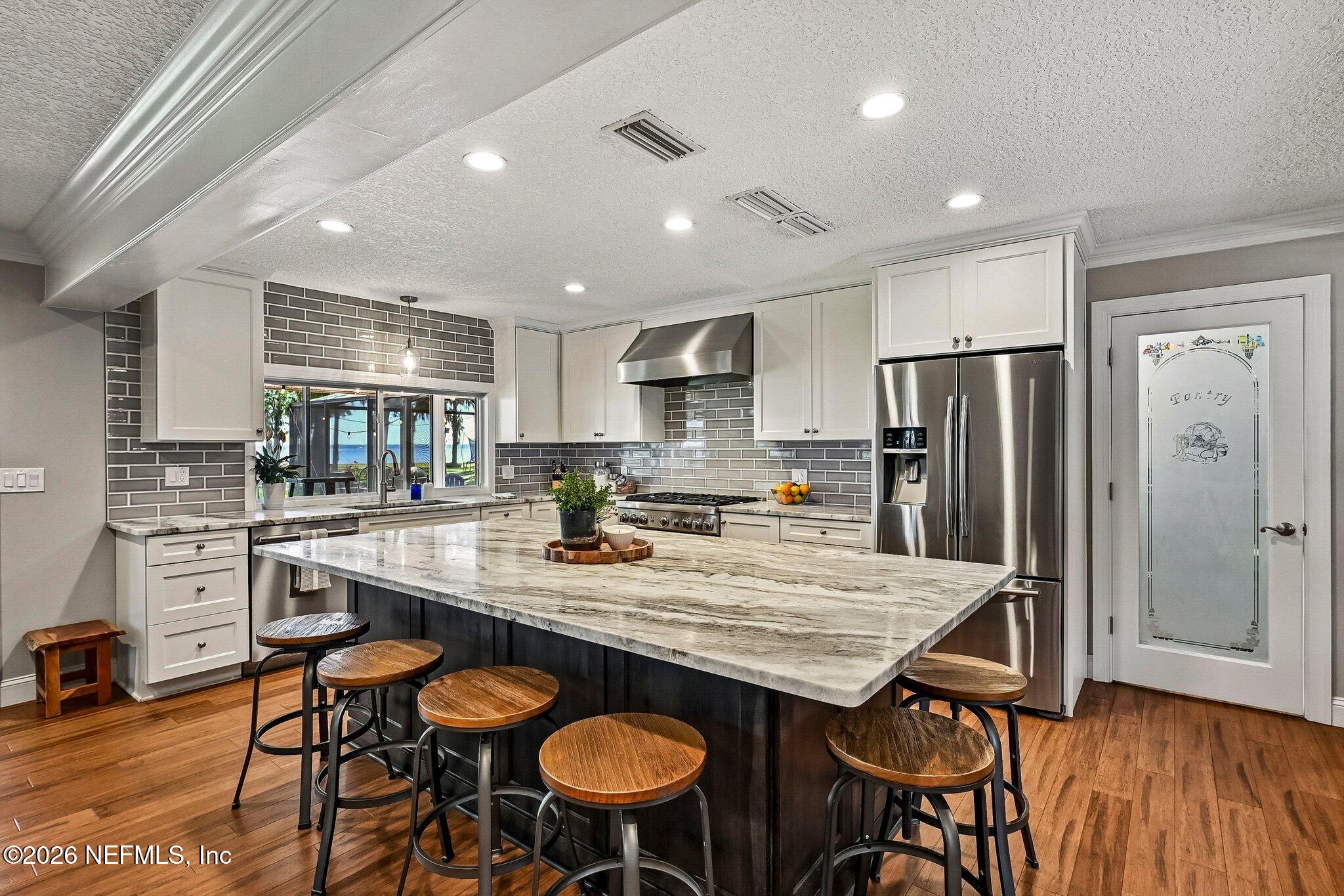 4745 Raggedy Point Road Fleming Island, FL 32003 - Photo 22 of 106 a kitchen with granite countertop kitchen island wooden cabinets and stainless steel appliances