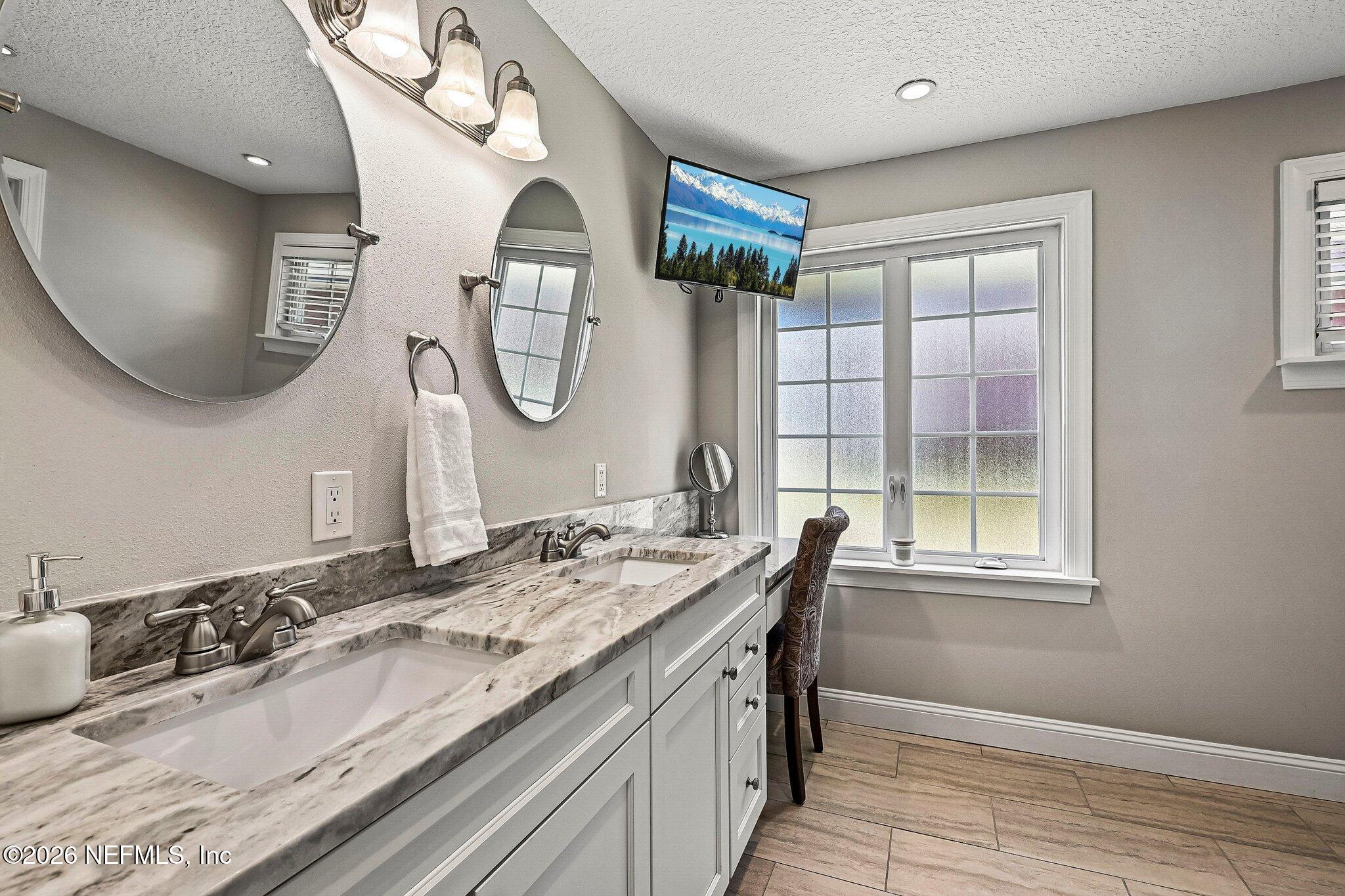 4745 Raggedy Point Road Fleming Island, FL 32003 - Photo 29 of 106 a bathroom with a granite countertop double vanity sink and a mirror