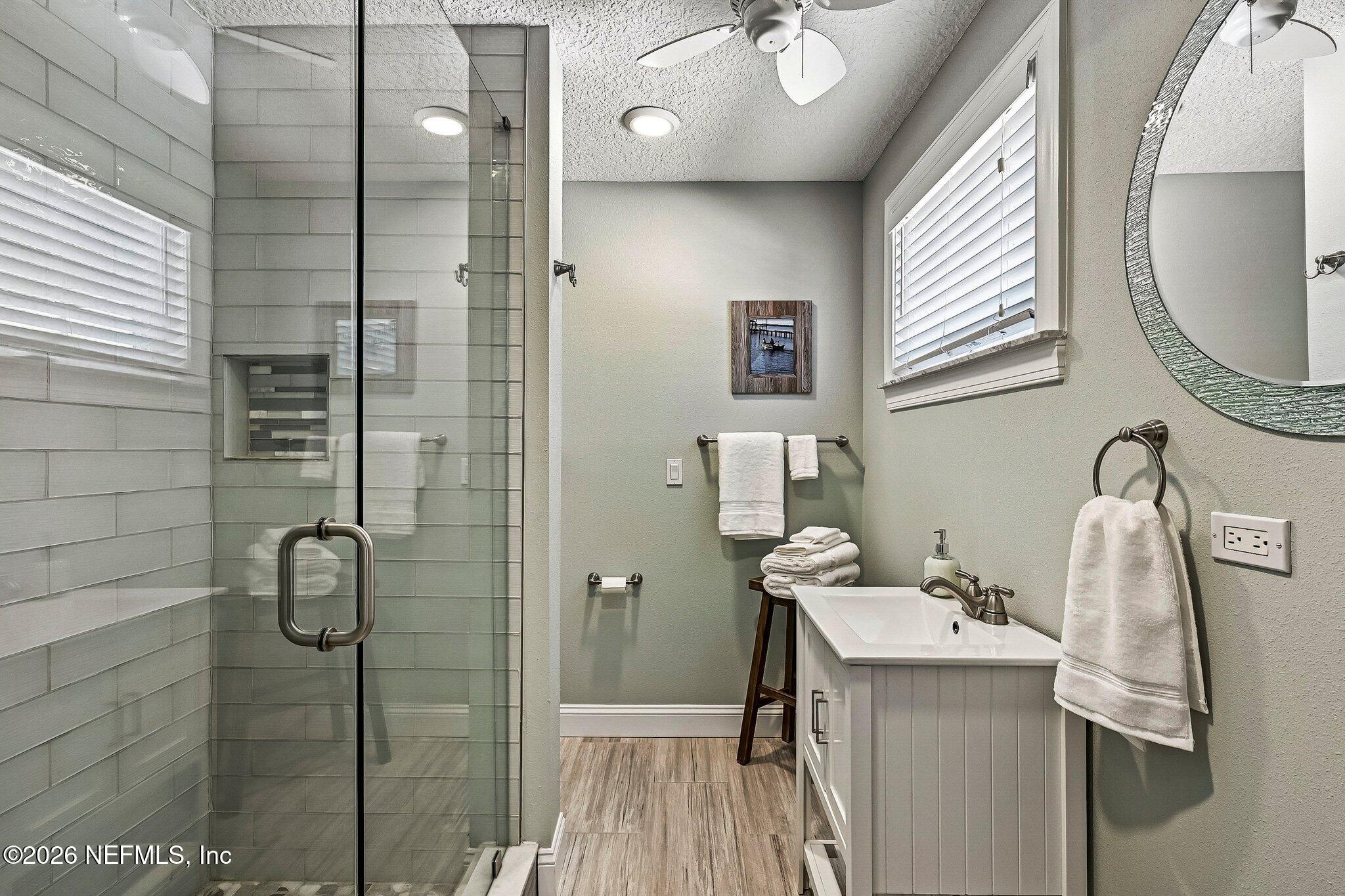 4745 Raggedy Point Road Fleming Island, FL 32003 - Photo 38 of 106 a bathroom with a granite countertop sink a mirror and shower