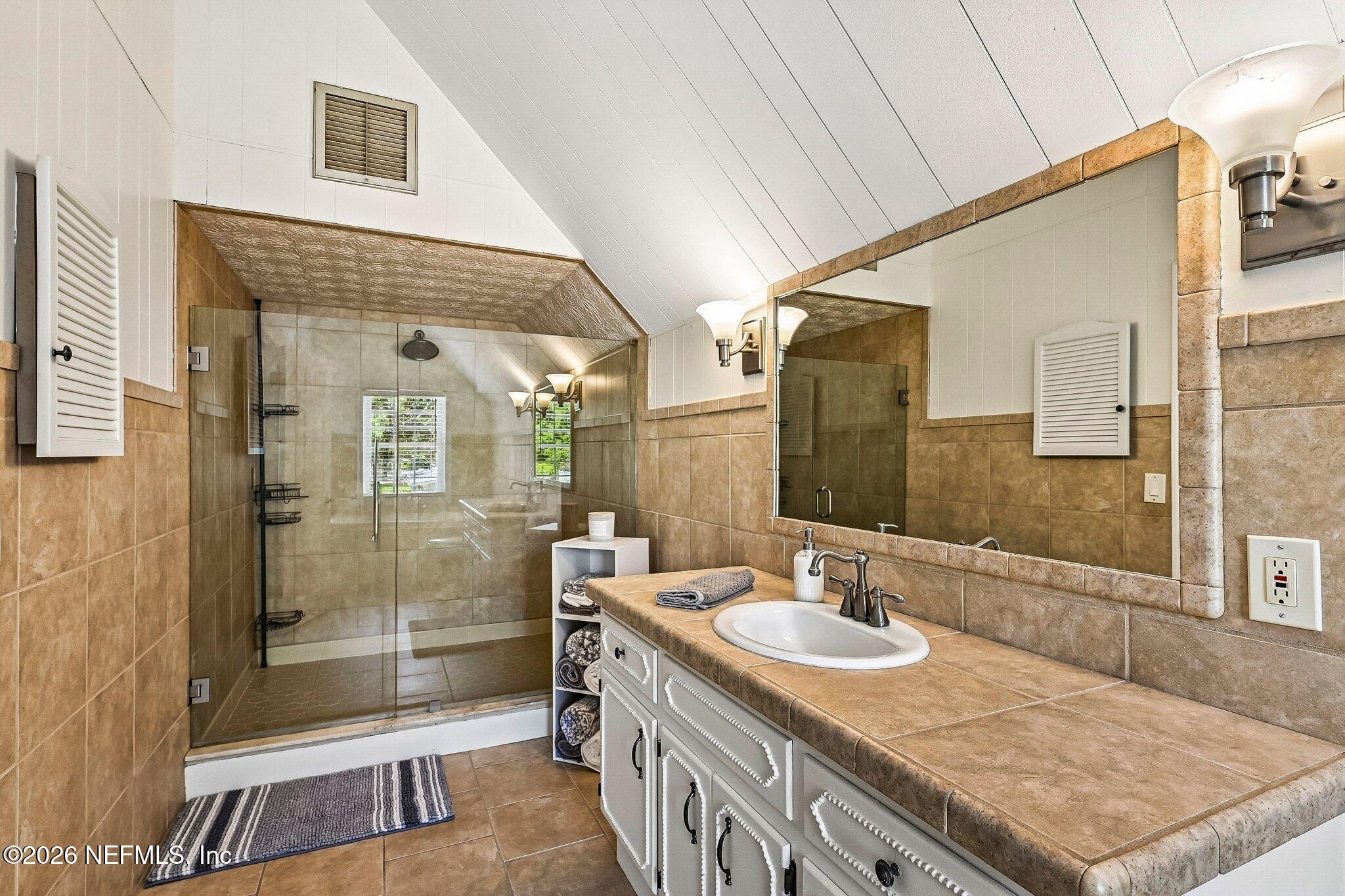 4745 Raggedy Point Road Fleming Island, FL 32003 - Photo 49 of 106 a bathroom with a granite countertop sink a mirror and a shower