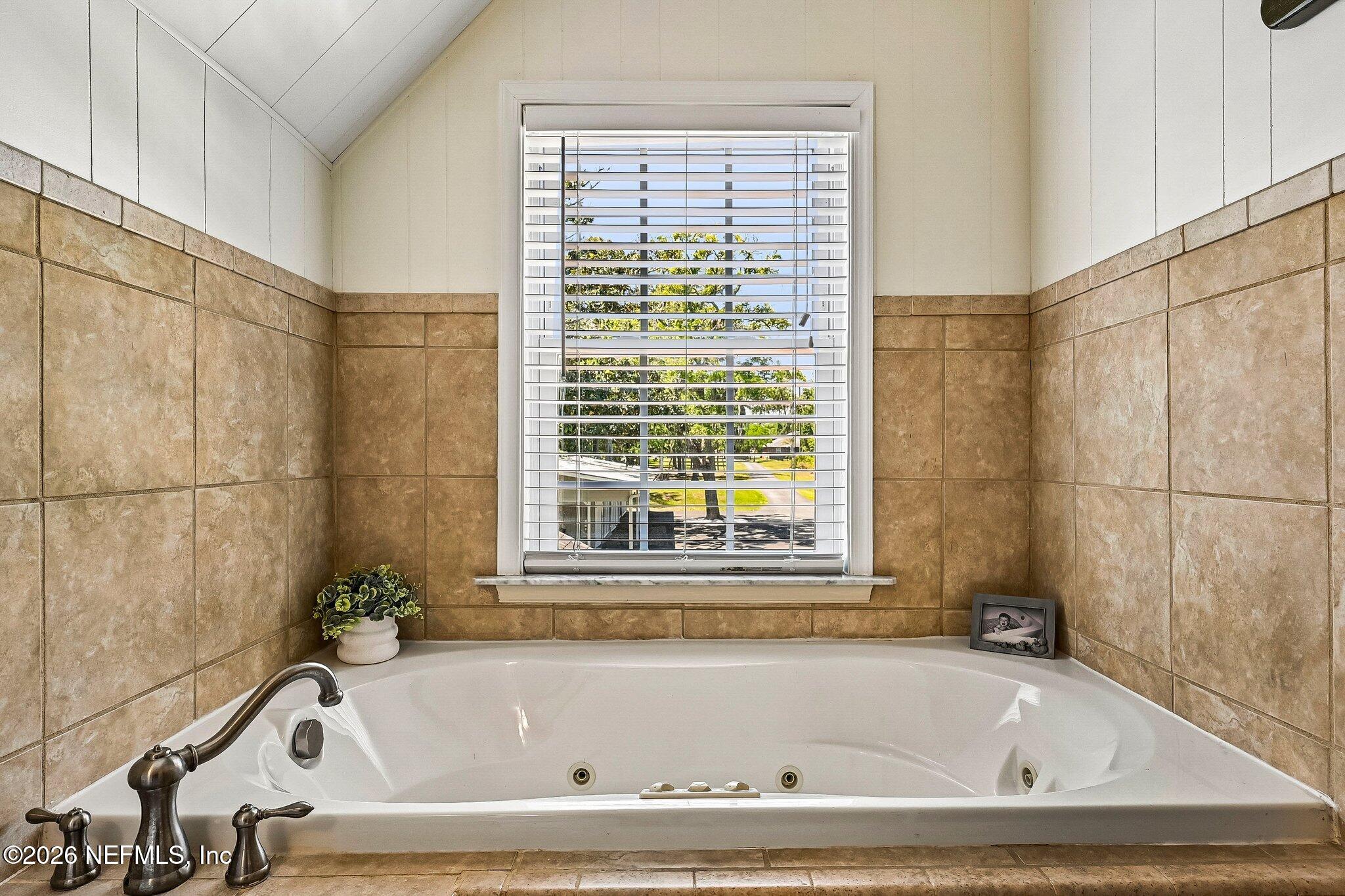 4745 Raggedy Point Road Fleming Island, FL 32003 - Photo 52 of 106 a white bath tub sitting next to a window