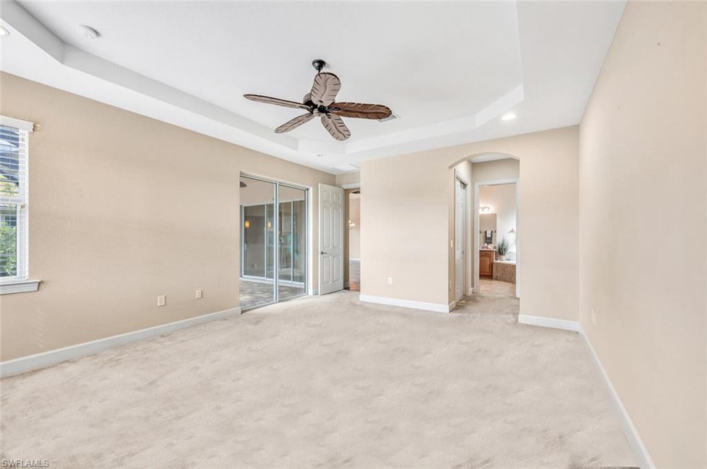 8237 Valiant Drive Naples, FL 34104 - Photo 17 of 35 Spare room with ceiling fan, light carpet, and a tray ceiling