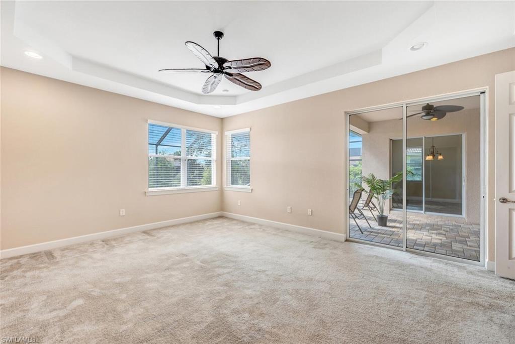 8237 Valiant Drive Naples, FL 34104 - Photo 18 of 35 Spare room featuring carpet floors, a tray ceiling, and ceiling fan