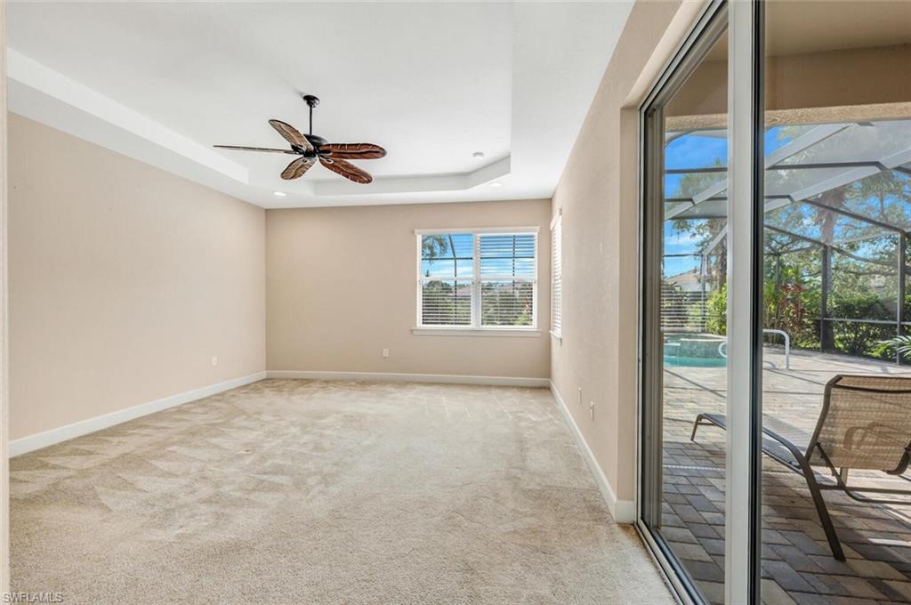 8237 Valiant Drive Naples, FL 34104 - Photo 19 of 35 Spare room featuring a tray ceiling, light colored carpet, and ceiling fan