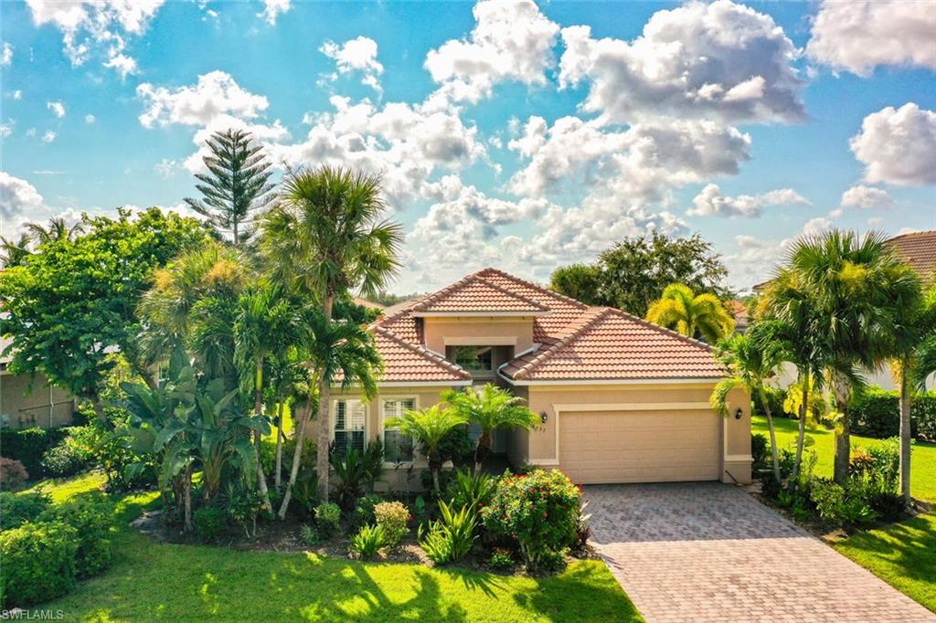 8237 Valiant Drive Naples, FL 34104 - Photo 2 of 35 Mediterranean / spanish house featuring a garage and a front lawn