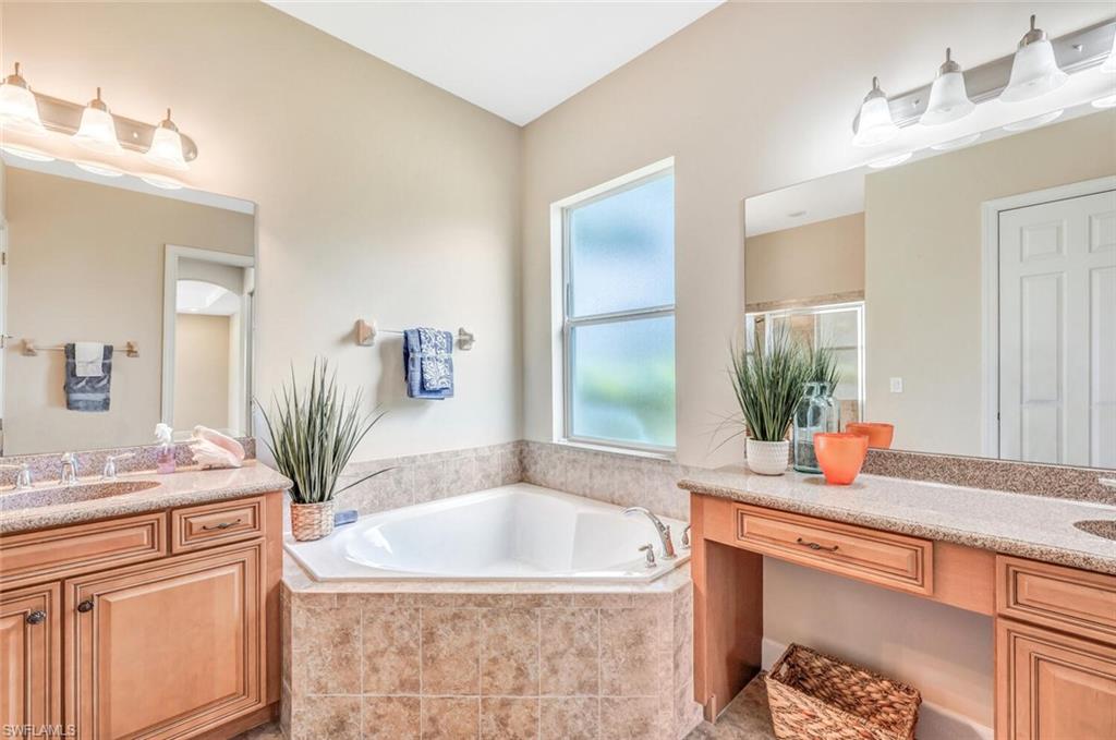8237 Valiant Drive Naples, FL 34104 - Photo 21 of 35 Bathroom with vanity and tiled bath