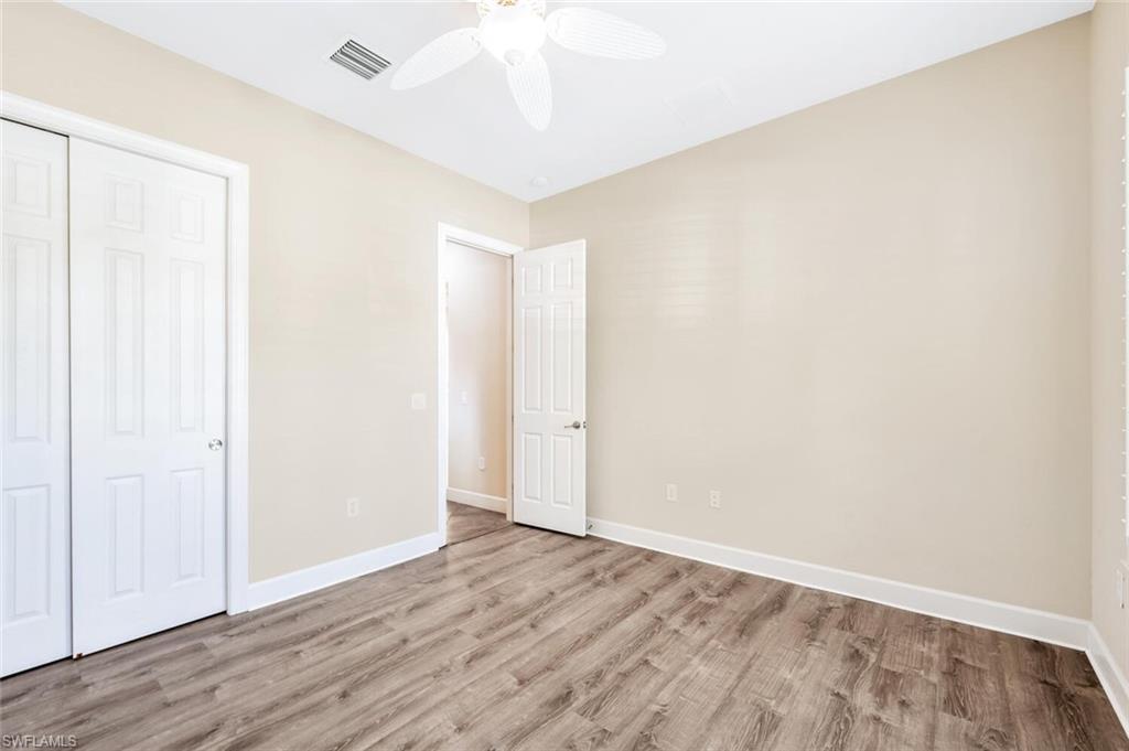 8237 Valiant Drive Naples, FL 34104 - Photo 23 of 35 Unfurnished bedroom with a closet, wood-type flooring, and ceiling fan