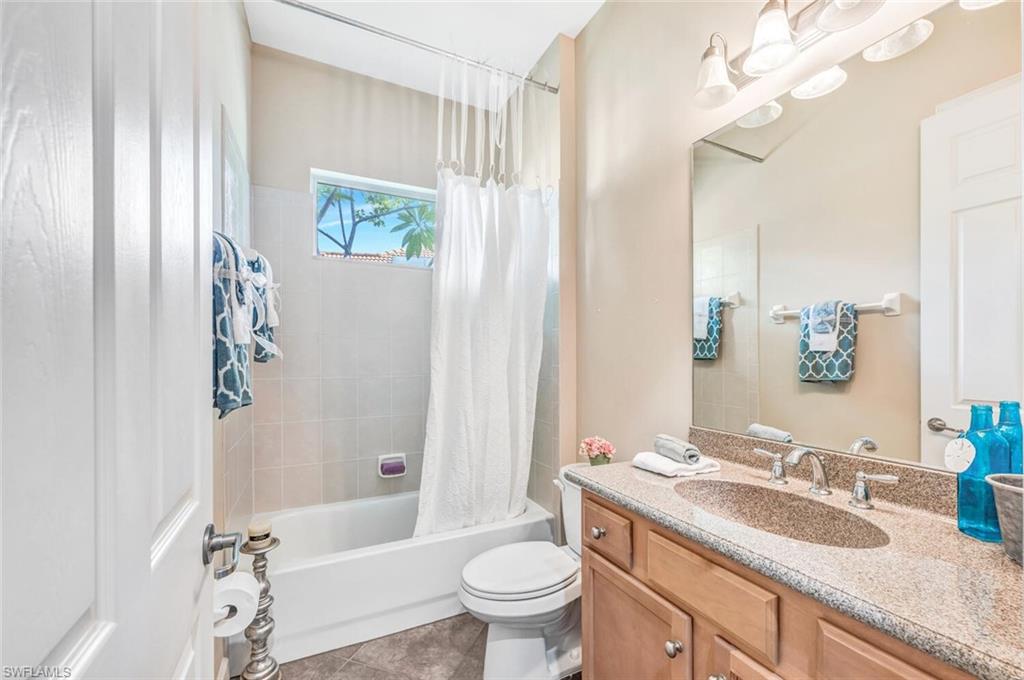 8237 Valiant Drive Naples, FL 34104 - Photo 25 of 35 Full bathroom with vanity, shower / bath combo with shower curtain, tile patterned flooring, and toilet