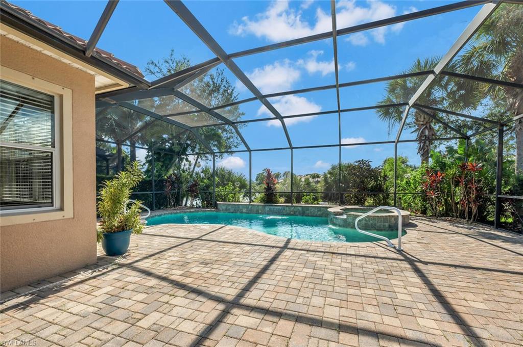 8237 Valiant Drive Naples, FL 34104 - Photo 28 of 35 View of pool featuring an in ground hot tub, a lanai, pool water feature, and a patio area