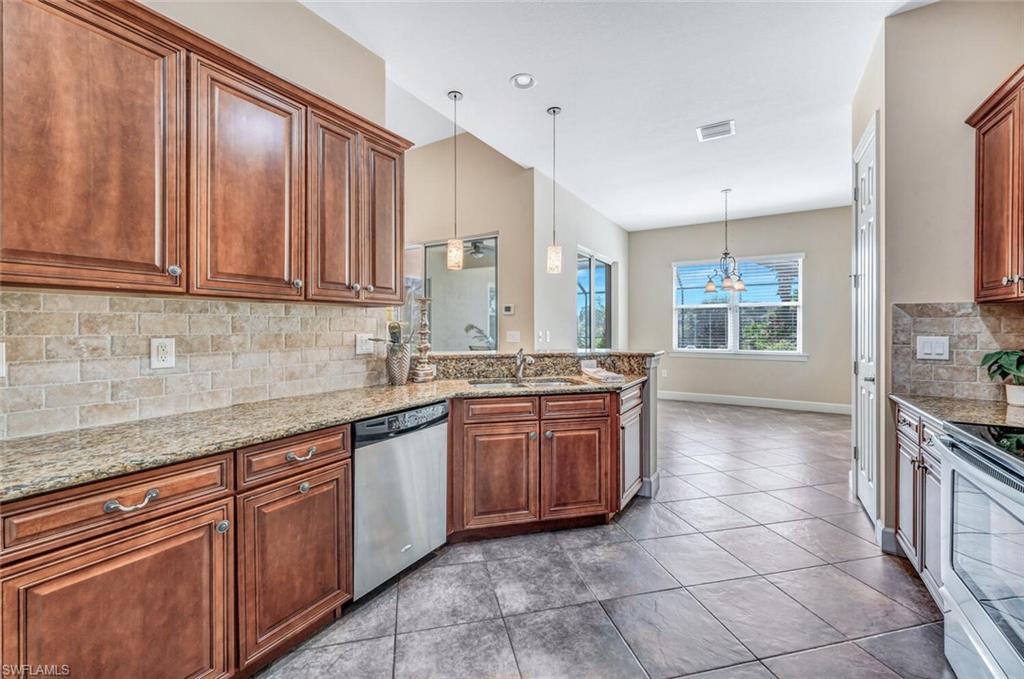8237 Valiant Drive Naples, FL 34104 - Photo 8 of 35 Kitchen featuring stainless steel appliances, sink, decorative light fixtures, light tile patterned floors, and decorative backsplash
