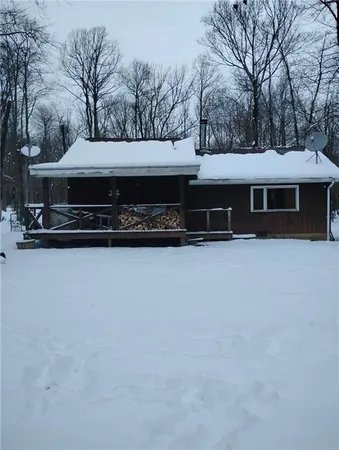 a front view of house with yard and trees in the background
