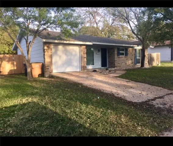 a view of a yard in front of a house with a large tree