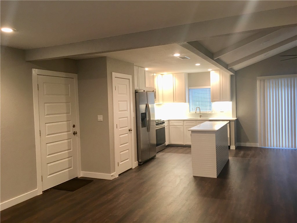 8307 Renton Drive Austin, TX 78757 - Photo 5 of 8 a kitchen with a refrigerator and white cabinets