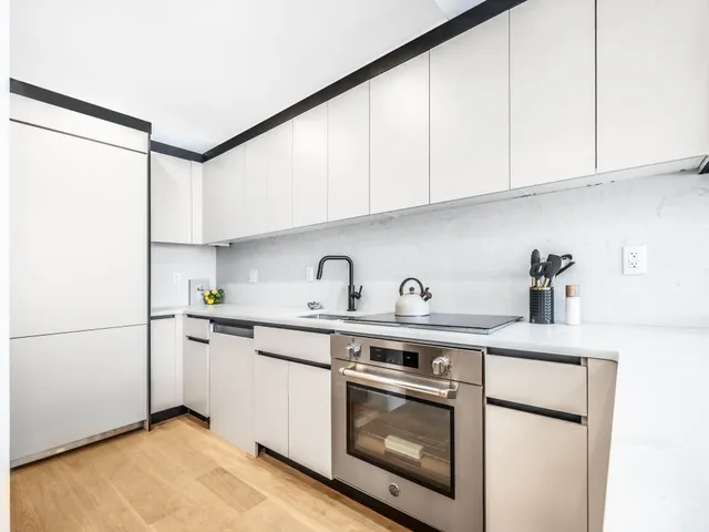 a kitchen with stainless steel appliances granite countertop white cabinets sink and refrigerator