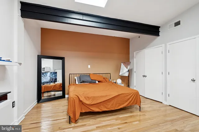 a bedroom with a bed and wooden floor