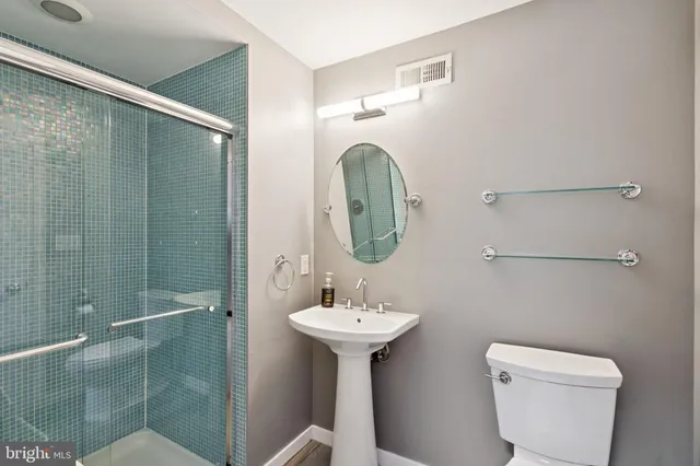 a bathroom with a toilet a sink and mirror