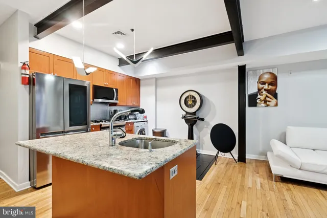 a kitchen with stainless steel appliances granite countertop a sink and a refrigerator