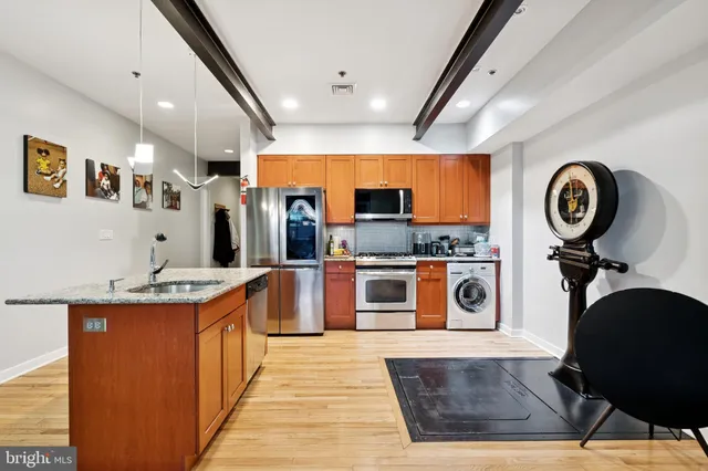 a kitchen with stainless steel appliances granite countertop a stove a sink and a refrigerator