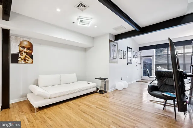 a living room with furniture and a wooden floor